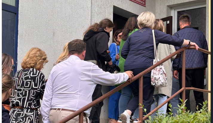 Zdjęcie przedstawia osoby wchodzące po schodach do budynku wśród, których są zarówno mężczyźni i kobiety